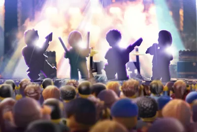 Four blurred LEGO rockstars on lit up stage with audience watching at LEGO Festival